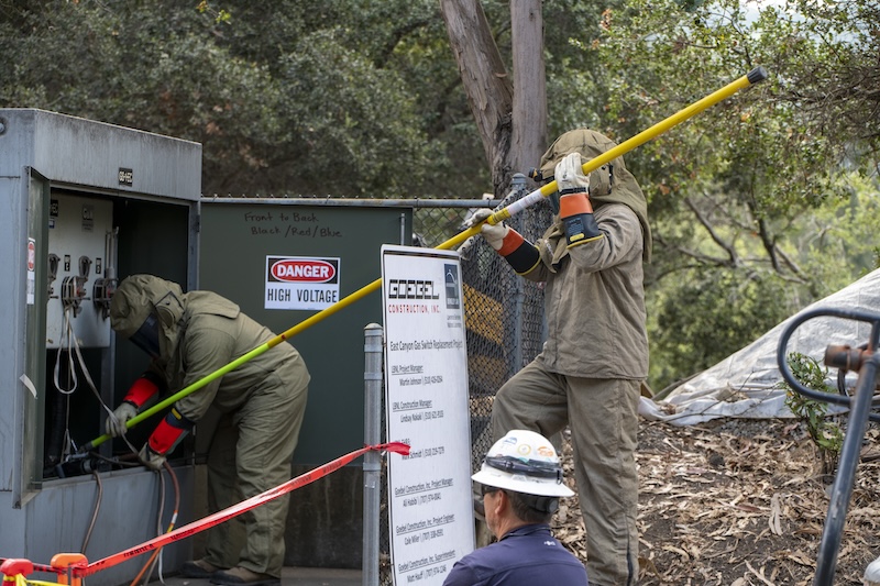 Manuel Gonzalez and Manuel Gonzalez, both High Voltage Electricians, Contra Costa Electric (CCE), prepare for a remote cut on high voltage power line at a power substation near the Strawberry Canyon Gate. The Lab’s East Canyon area’s 21 buildings are powered down over the course of five days, August 16 to 21, 2022, as part of the East Canyon Infrastructure Project, a joint infrastructure and maintenance project between Facilities and the Projects & Infrastructure Modernization Divisions to execute multiple projects in the area, at Lawrence Berkeley National Laboratory (Berkeley Lab), in Berkeley, California, 08/16/2022 to 08/21/2022.